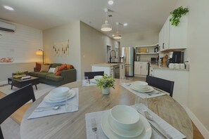A modern apartment with a dining area, kitchen, and living space. - Travelers Dream - 2 Homes 1 Stay (Colorado Springs)