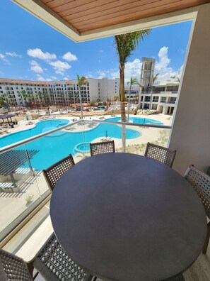 Un balcon donnant sur une piscine et les bâtiments de l’hôtel.