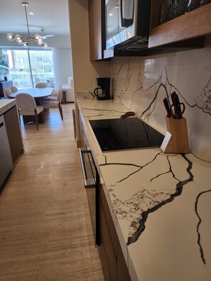 Une cuisine moderne dotée d’un plan de travail en marbre, d’une machine à café et d’un bloc à couteaux.