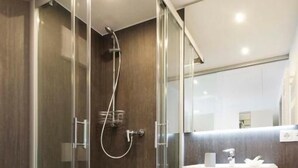 A modern bathroom with a glass-enclosed shower, a wooden vanity, and a white toilet. - Landgasthof Lamm (Aalen-Ebnat)