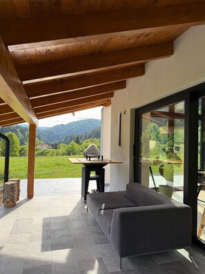 A modern outdoor seating area with a view of a mountainous landscape.
