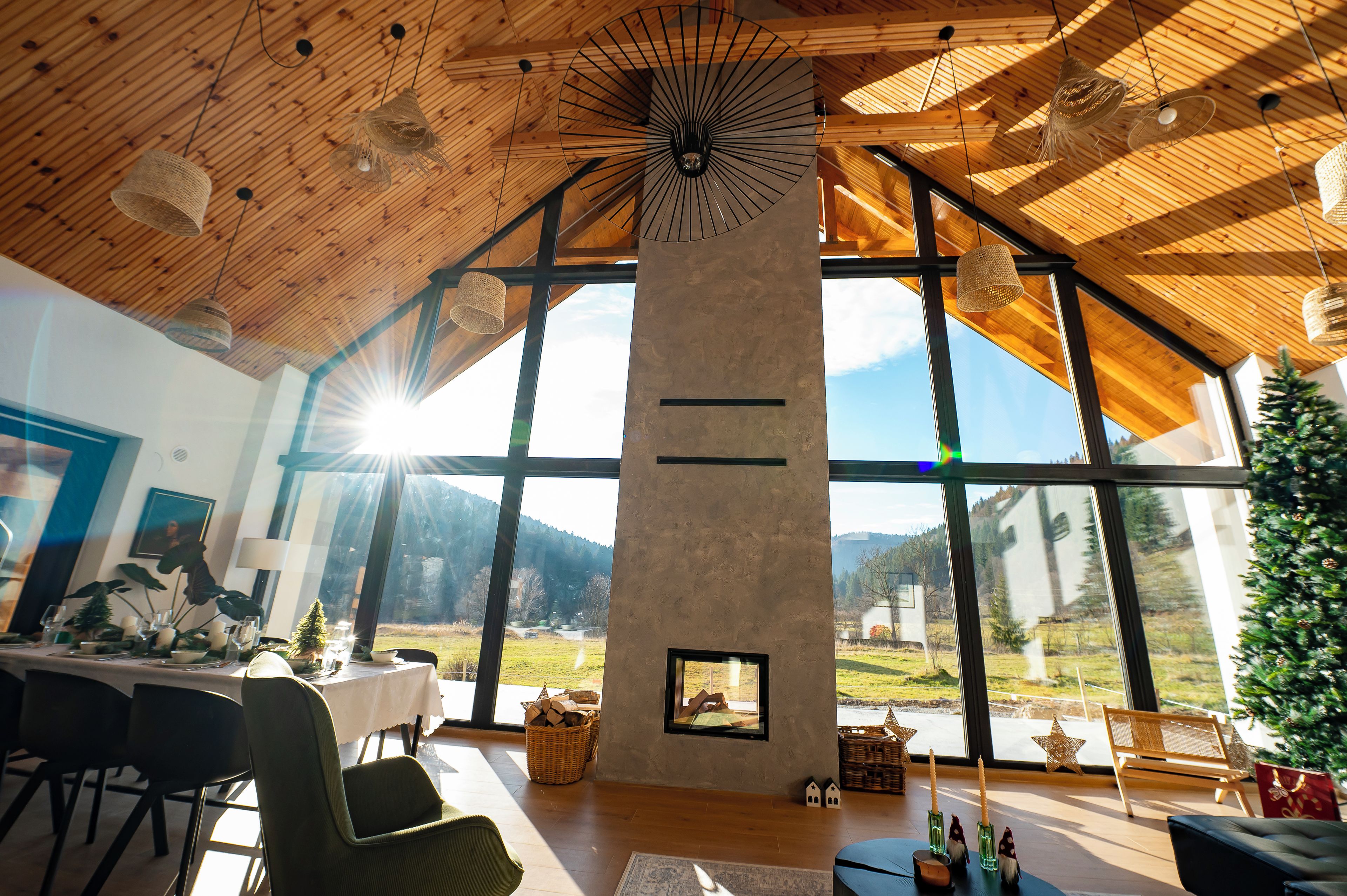 A spacious room with a high ceiling, large windows, and a fireplace.
