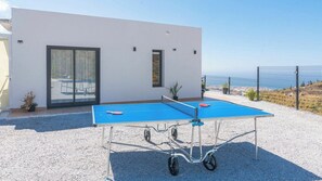 A ping pong table set up outdoors with a modern building in the background. - Villa Turística Palomas Torrox by Ruralidays (Málaga)