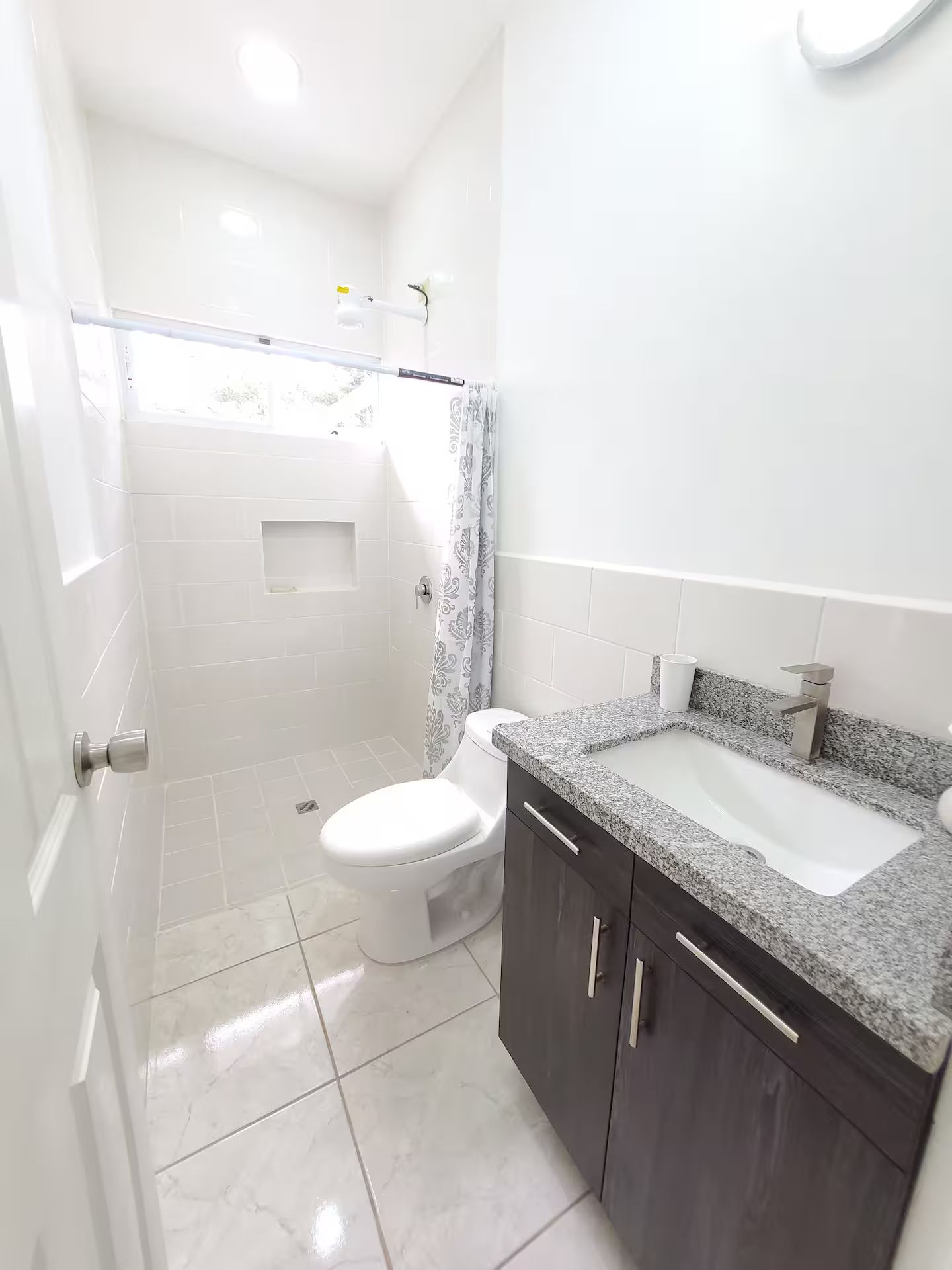 Un baño con inodoro, ducha y lavamanos.