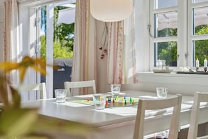 A dining table with a board game, glasses, and a candle holder. - Cosy holiday home in beautiful Kulhuse (Jægerspris)