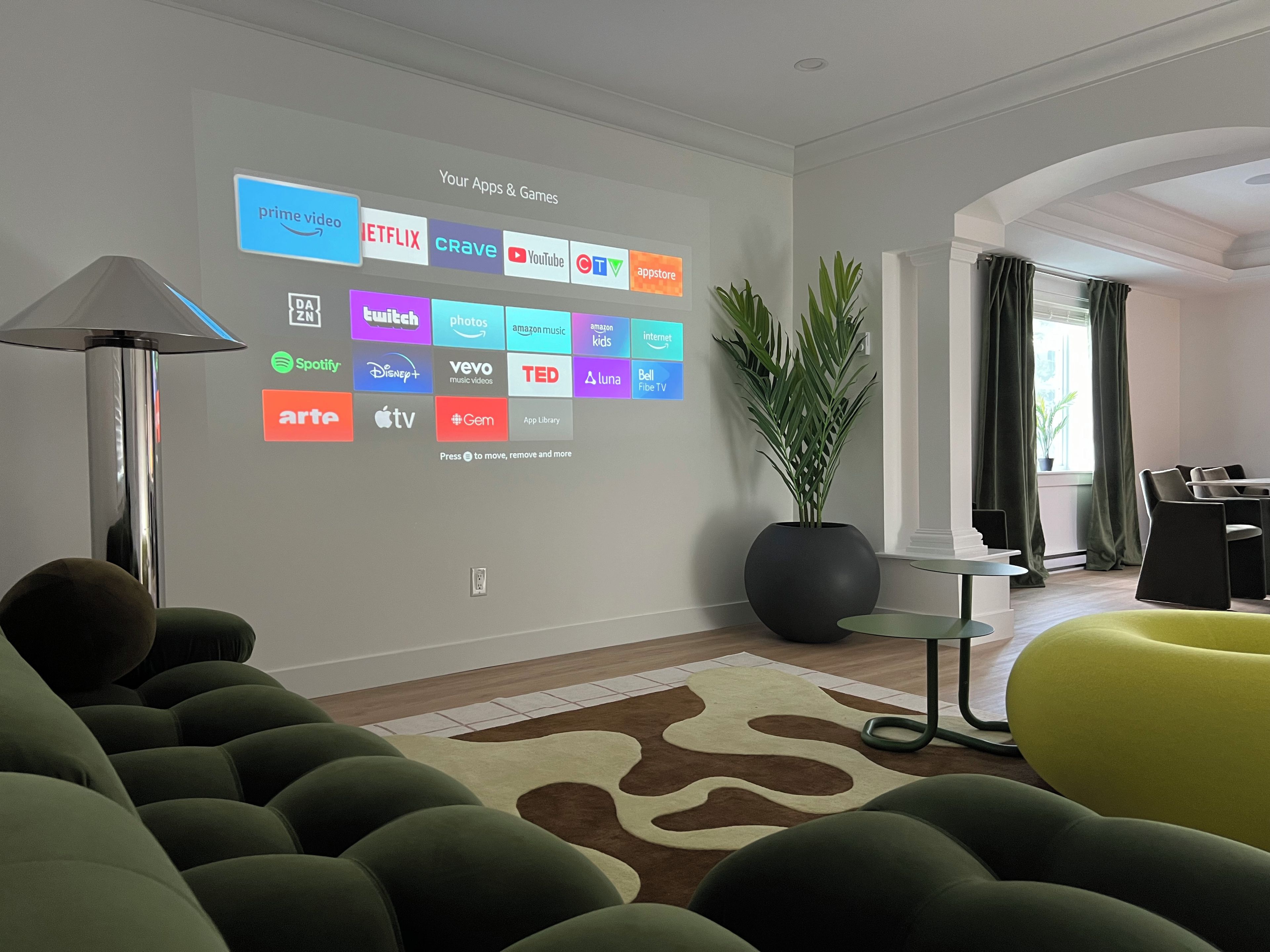 Un salon moderne avec un écran fixé au mur qui affiche les différentes plateformes de diffusion en continu.