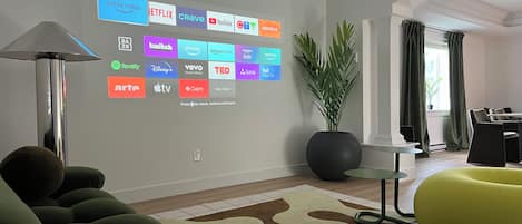 A modern living room with a wall-mounted display of various streaming services.