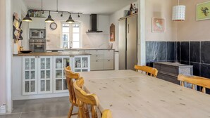 Une cuisine spacieuse avec un îlot central, des chaises en bois et une table à manger.
