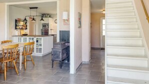 Une cuisine moderne avec un coin repas, un escalier et un espace de vie.