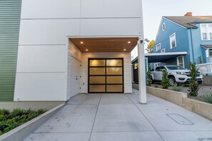 A garage entrance with a wooden overhang and a glass door. - Designer Townhome Near UO, 3 King Suites + Chefs Kitchen (Eugene)