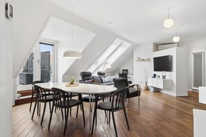 A modern loft with a dining area, seating, and a kitchen. - Lovely apartment in the heart of Skagen town (Skagen)
