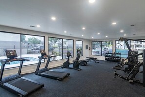 A gym with treadmills, elliptical machines, and weight equipment.