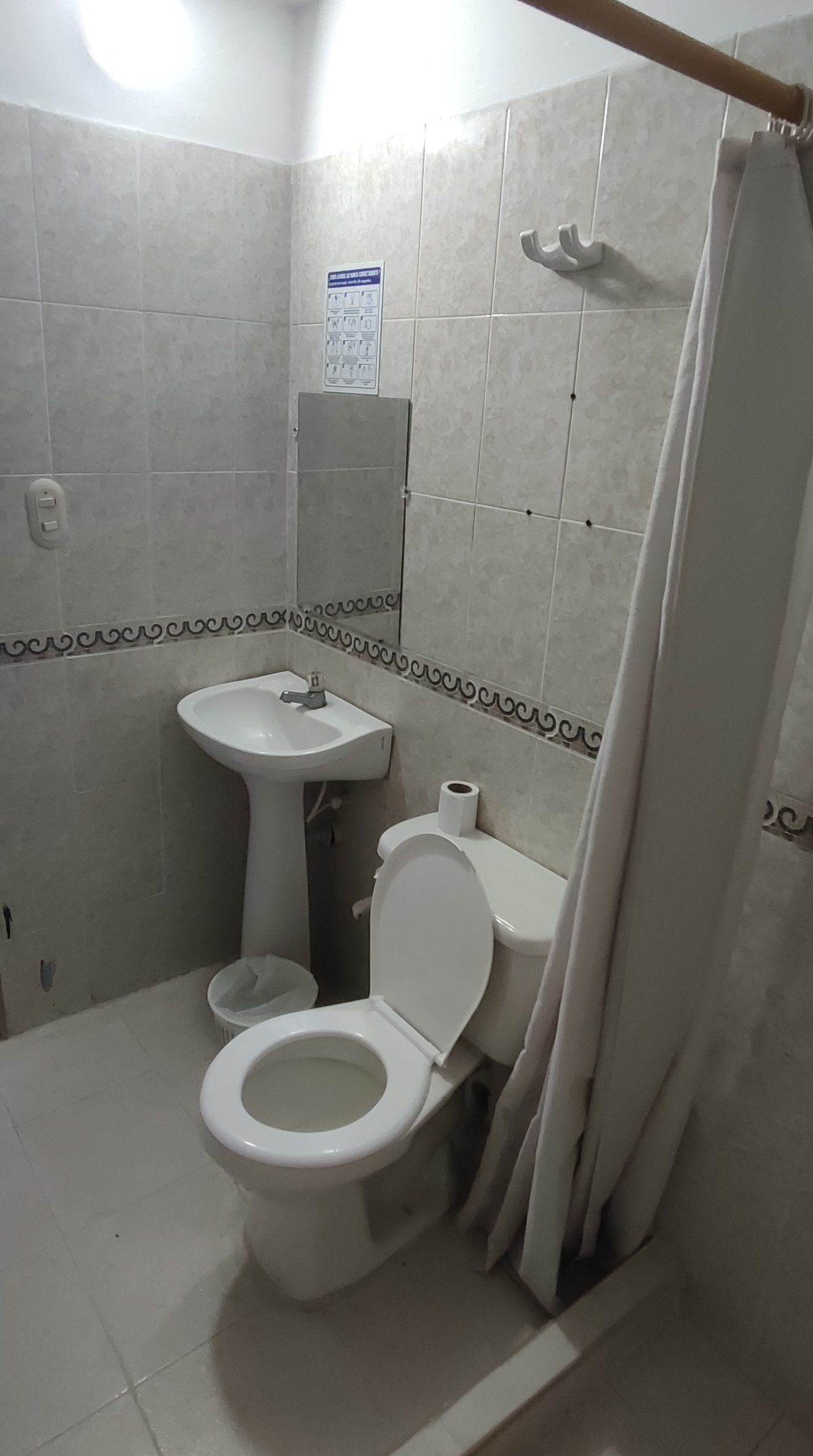 Un baño con inodoro, lavamanos y ducha.