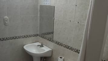 Un baño con inodoro, lavamanos y ducha.