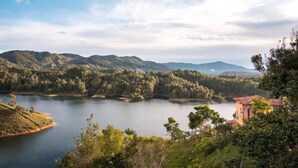 Un lac entouré de collines, avec un bâtiment situé sur la droite.