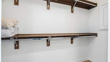Una habitación con un banco de madera, una pared blanca y una puerta blanca.