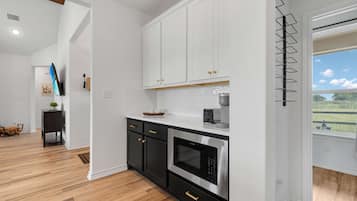 A modern kitchen with white cabinets, a black countertop, and a stainless steel oven.
