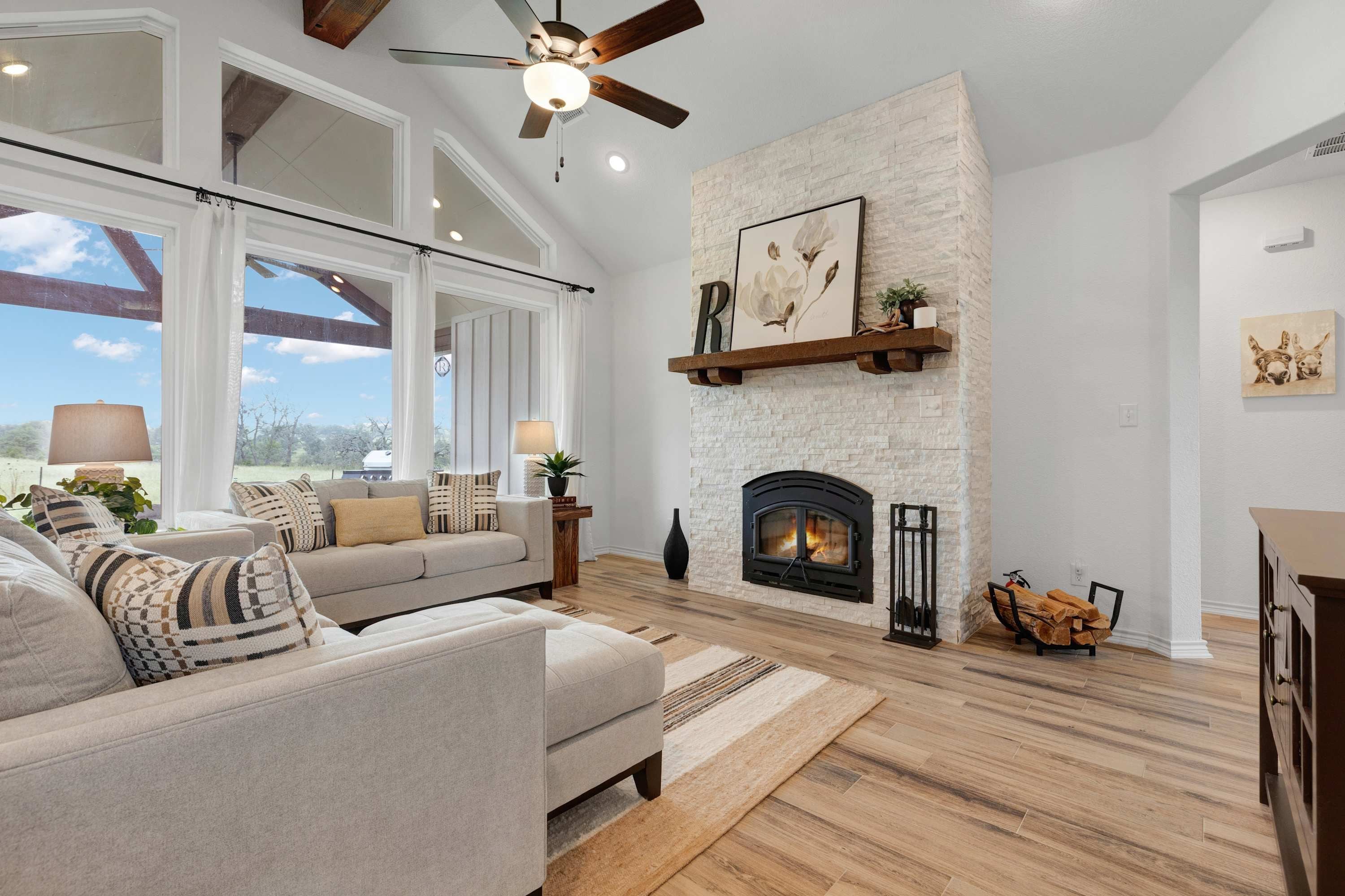 A living room with a fireplace, a sofa, and a ceiling fan.