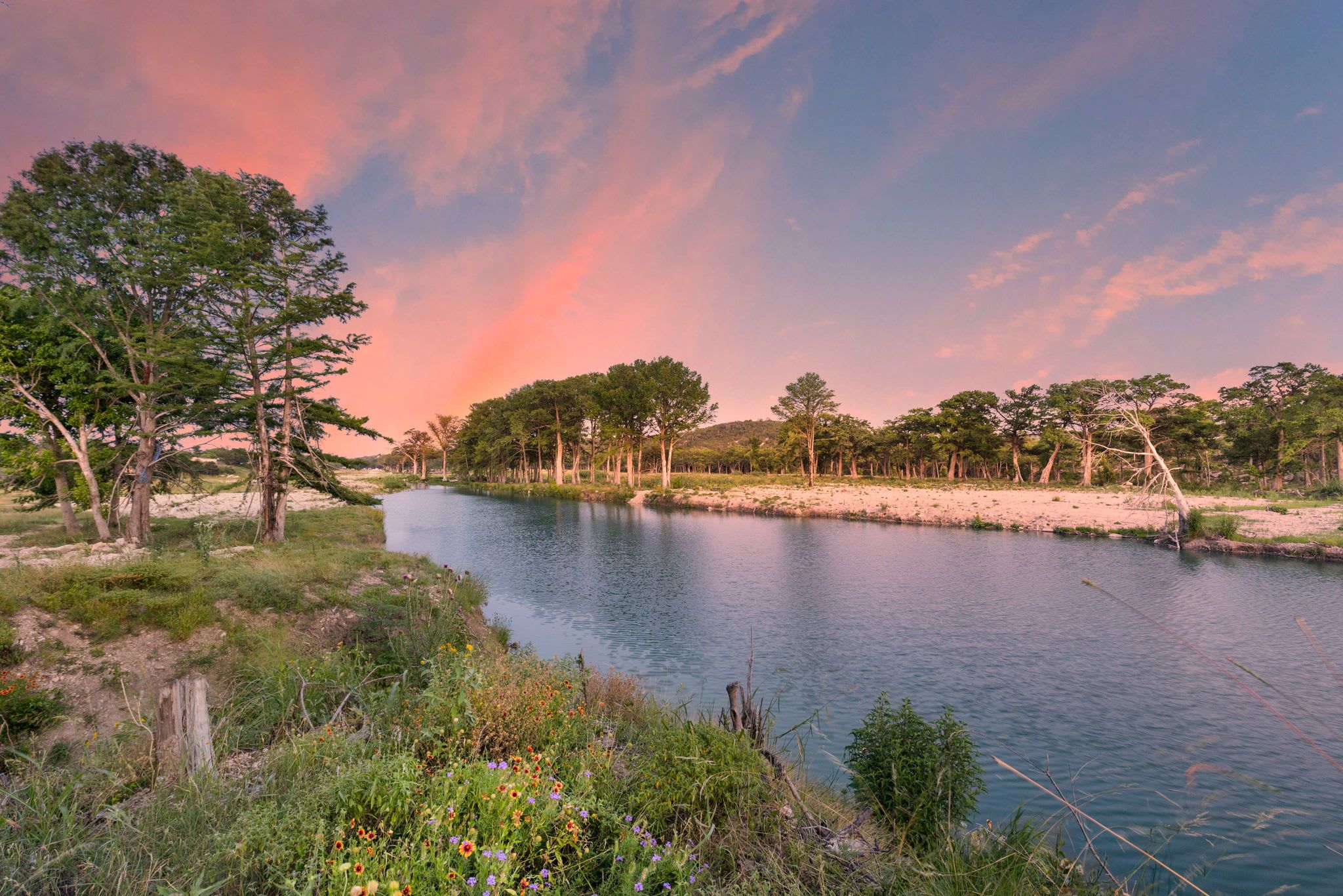 A river with trees and greenery on both sides.