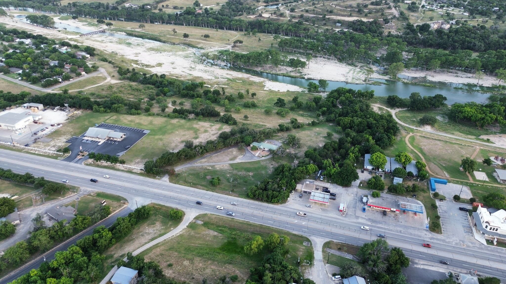 An aerial view of a highway with multiple lanes, intersecting roads, and a mix of residential and commercial buildings.