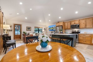 A modern kitchen with wooden cabinets, a stainless steel refrigerator, and a microwave.