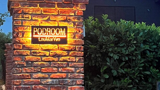 A brick wall with a neon sign reading 'PODROOM' and 'LouMarYvo'. - Cozy little house near Zagreb and airport. Private garden around house. (Dugo Selo)