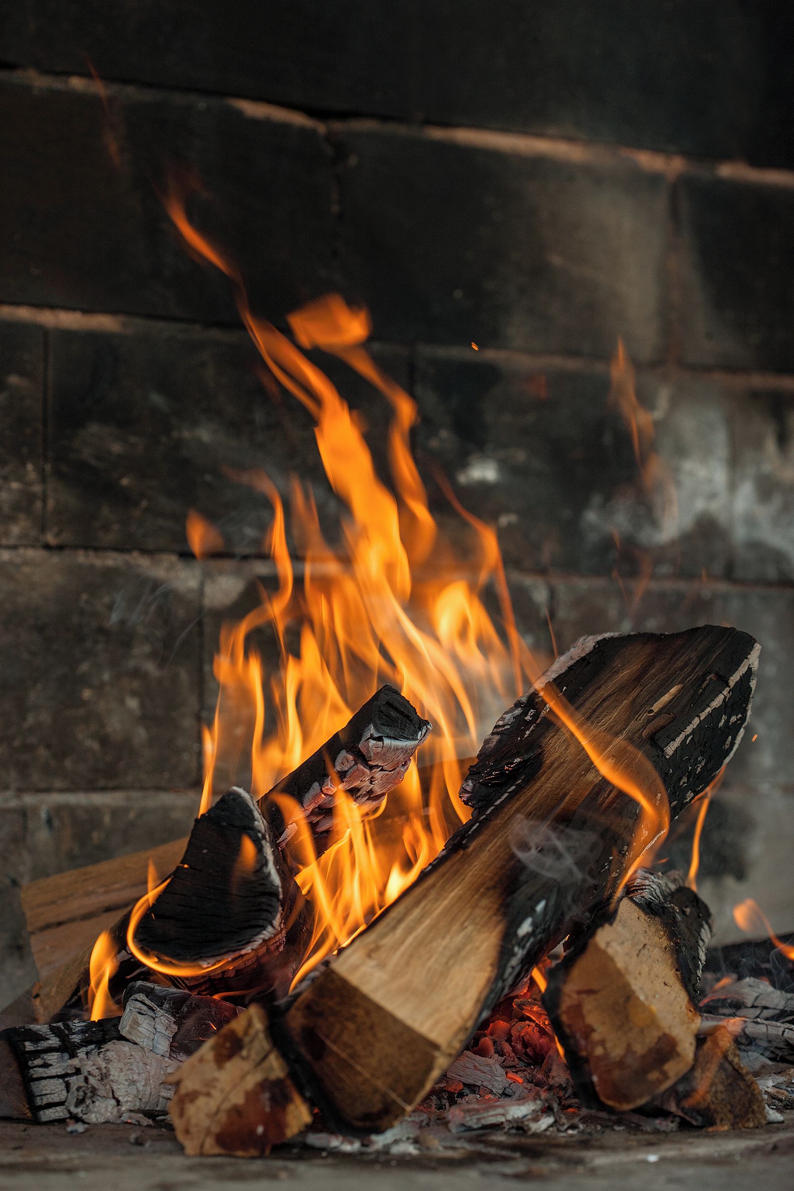 A fireplace with burning logs and flames.