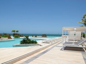 A pool area with lounge chairs and a view of the ocean. - Kanaa Marina - Luxury Oceanview Residence (Progreso)