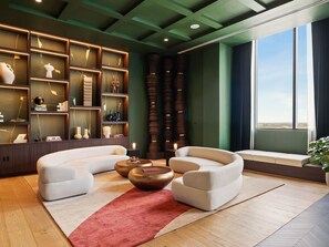 A modern living room with a curved sofa, a red rug, and a bookshelf filled with decorative items. - Modern Downtown Miami Retreat with Private Balcony (Miami)