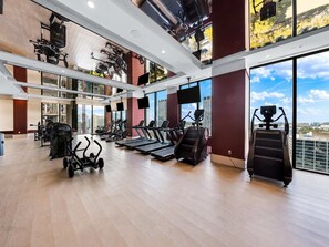 A gym with treadmills, elliptical machines, and weight equipment. - Modern Downtown Miami Retreat with Private Balcony (Miami)