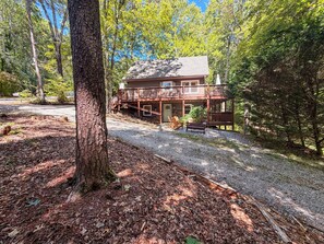 A cabin with a deck and a covered porch, surrounded by trees. - Heavenly Honey Bear | Helen Getaway w/ Fire Pit (Helen)