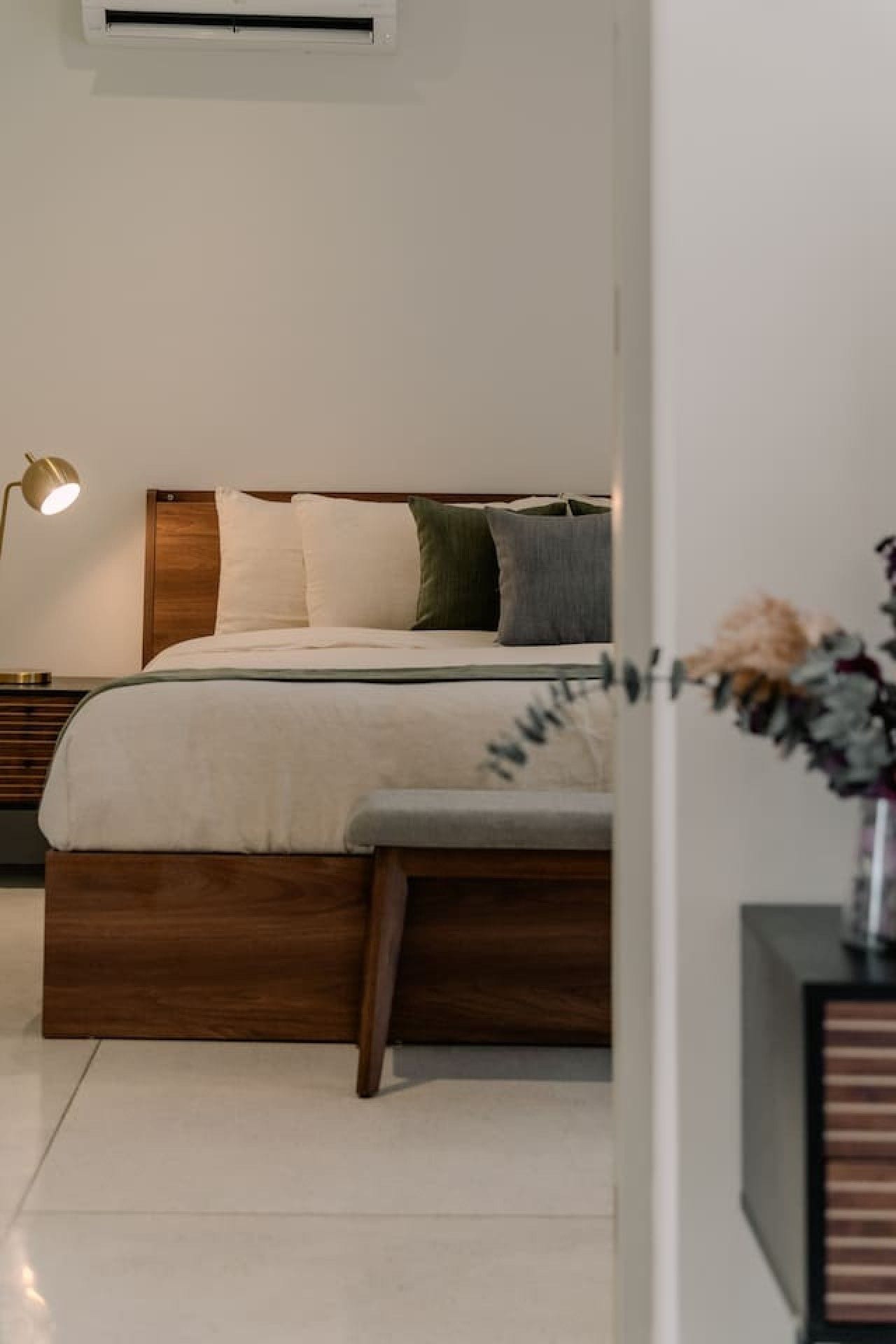 Une chambre à coucher moderne avec un cadre de lit en bois, une lampe de chevet et une table de nuit.