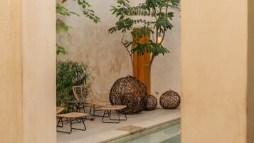 A pool area with a seating arrangement and decorative elements.