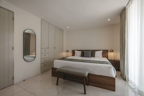 Een moderne slaapkamer met een groot bed, een nachtkastje, een spiegel en een kledingkast.
