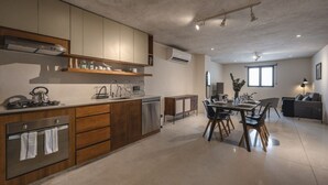 Cozinha moderna com área de jantar, com forno embutido, eletrodomésticos em aço inoxidável e mesa de jantar com cadeiras.