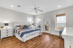 A bedroom with a bed, nightstands, a ceiling fan, and a wooden floor. - Bikini Bottom · New Listing! Steps to Beach, Gulf-View Porches & Pool (Gulf Shores)