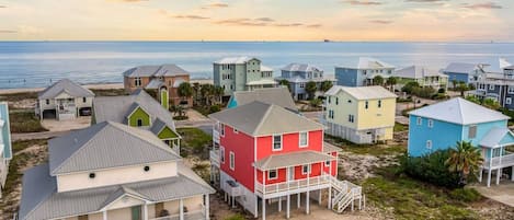 A coastal residential area with houses featuring balconies and a view of the sea.
