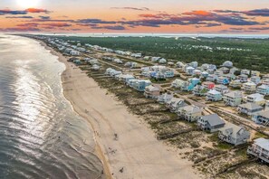 A coastal residential area with houses aligned along the beach, featuring a sandy shoreline and a view of the ocean. - Bikini Bottom · New Listing! Steps to Beach, Gulf-View Porches & Pool (Gulf Shores)