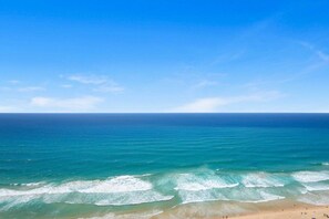 Uma praia com águas azul-claras e areal arenoso.