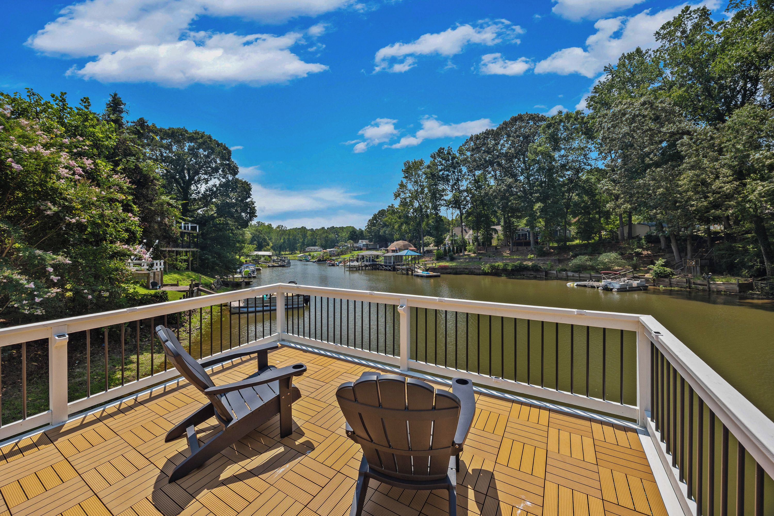 A deck with two chairs overlooking a river.