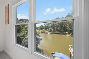 A room with large windows overlooking a body of water, a dock, and a gazebo.