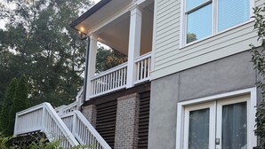 A two-story house with a covered porch, a staircase, and a front door. - Marvelous 5-bedroom house with tons of space in 5 Points (Athens)