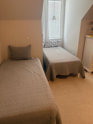 A bedroom with two beds, a window with blinds, a hanging light, and a dresser. - Marvelous 5-bedroom house with tons of space in 5 Points (Athens)