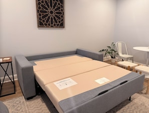 A compact bed with storage drawers, a bedside table, a chair, and a small desk with a plant. - Marvelous 5-bedroom house with tons of space in 5 Points (Athens)