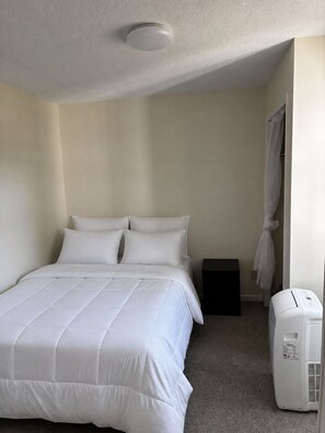 A hotel room with a bed, a heater, and a curtain. - Escape to a cozy 4-bedroom, 2-bath home with a hot tub in historic Beverly (Beverly)