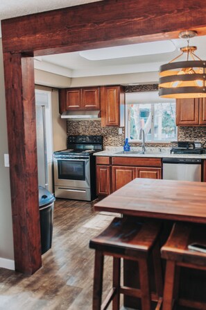 A kitchen with wooden cabinets, a stainless steel stove, and a window with a view.