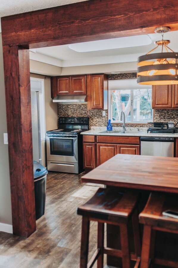 A kitchen with wooden cabinets, a stainless steel stove, and a window with a view.