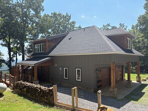 A modern house with a sloped roof, a covered porch, and a stone wall. - Adagio 2: Luxury 2-bd 1-ba apt with stunning views close to Little River Canyon. (Gaylesville)
