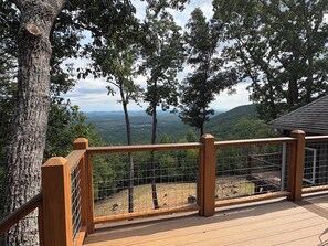 A wooden deck with a metal railing overlooking a forested landscape. - Adagio 2: Luxury 2-bd 1-ba apt with stunning views close to Little River Canyon. (Gaylesville)