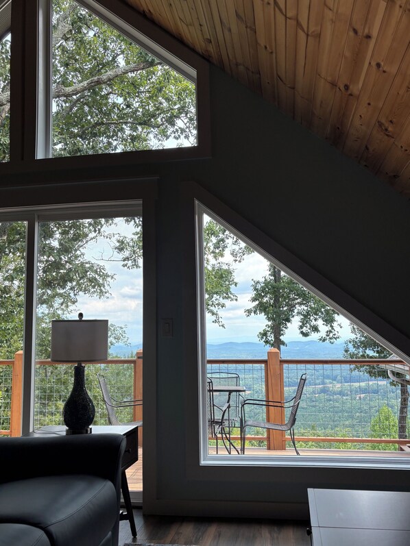 A room with large windows offering a view of a mountainous landscape.